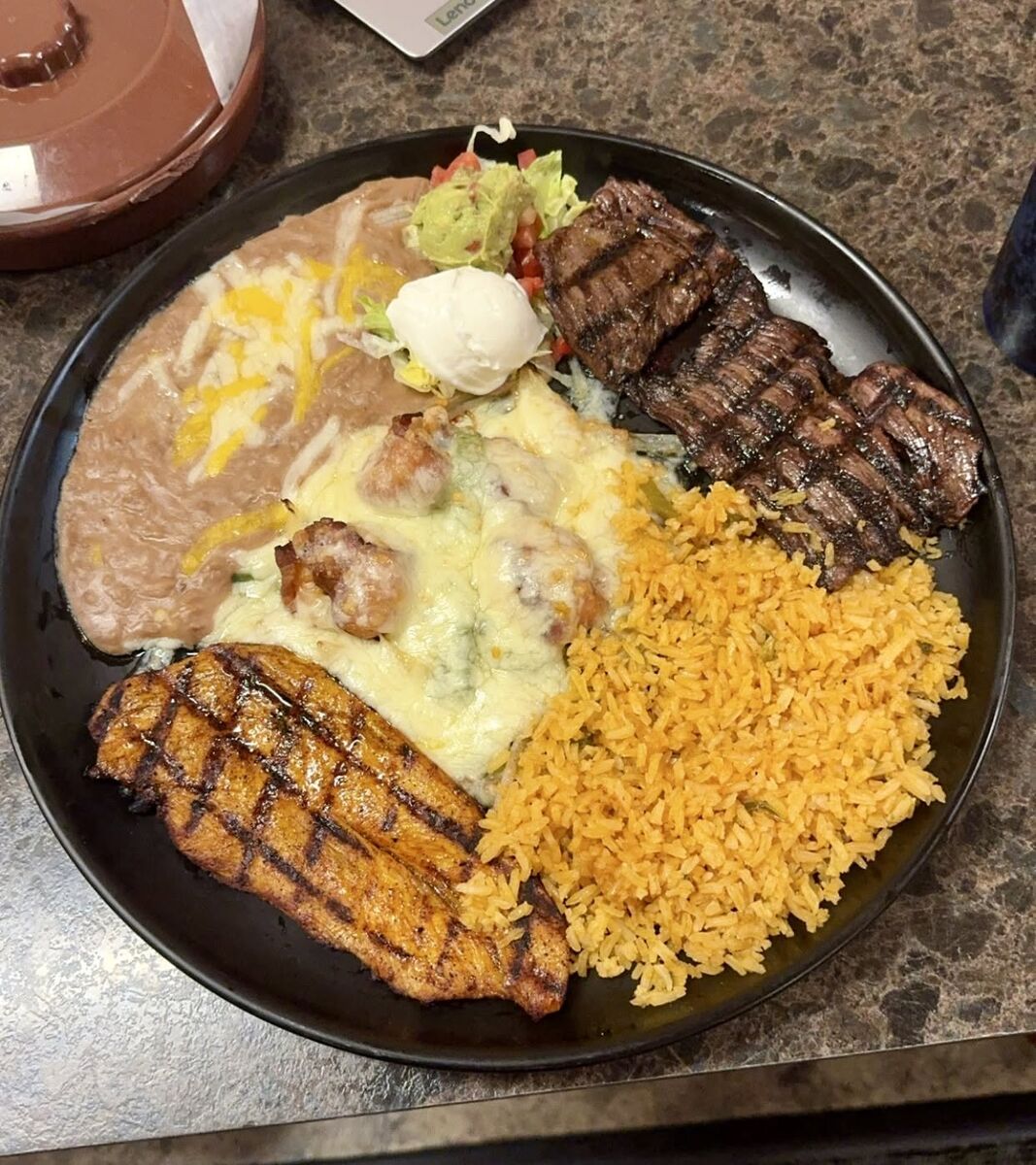 Charbroiled steak and chicken with Spanish rice